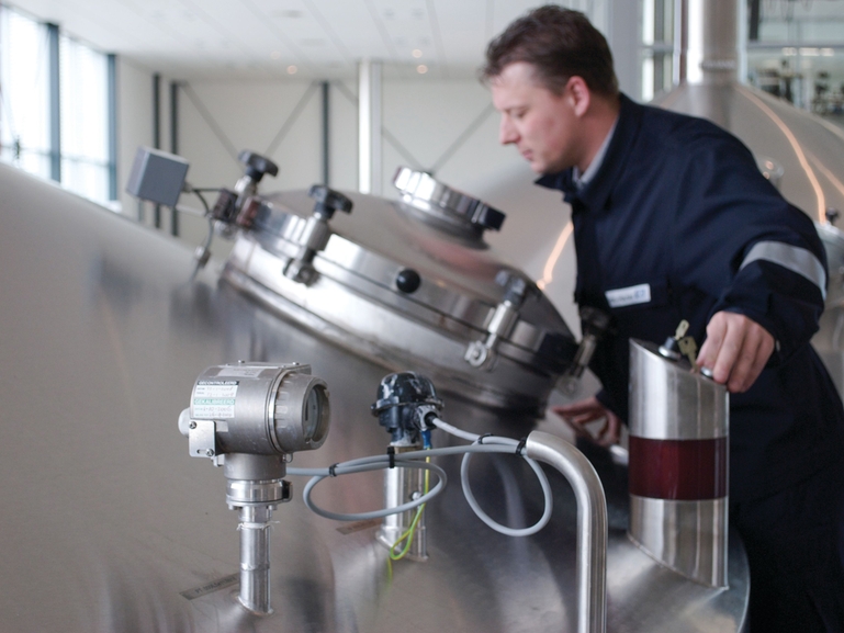 Brewhouse employee looking in a tank Quality control in the brewhouse